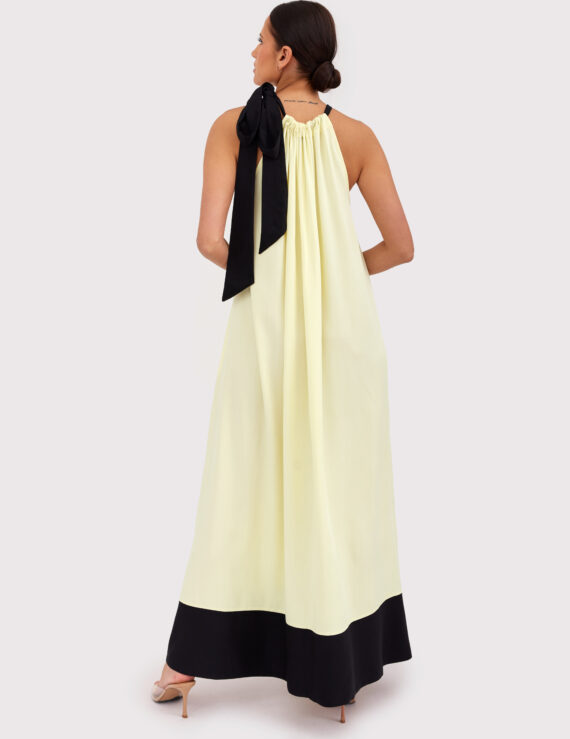 Modelka w letniej sukience maxi w kolorze maślanym, z czarnym wiązaniem na szyi – stylizacja Yellow Mood na lato