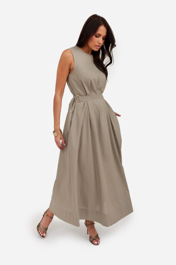 Kobieta w beżowej sukience maxi z wiskozy i lnu, bez rękawów, z regulowaną talią na klamrę — elegancki letni model.